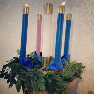 an advent wreath with the first two blue candles alight