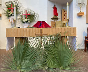 St. Mark's altar is adorned with fan palm fronds, and red chalice covere